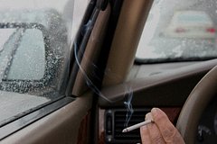 Названы три неочевидных минуса курения в машине